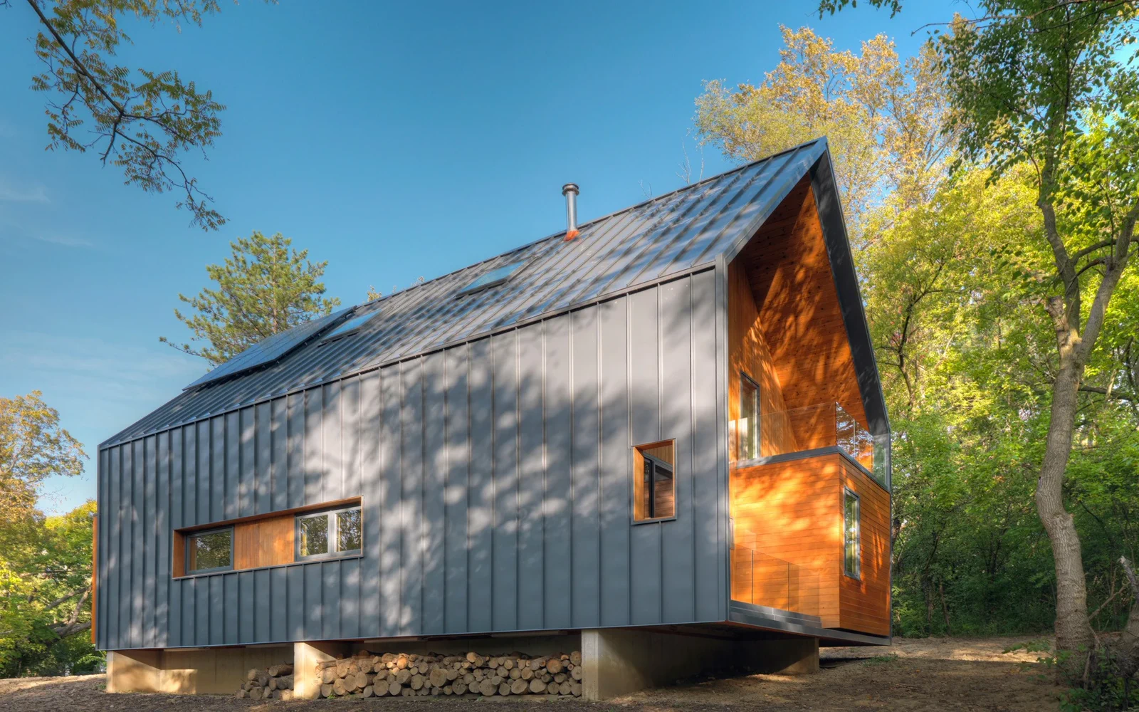 Trekledd bolig med terreng, adkomst og natur rundt huset