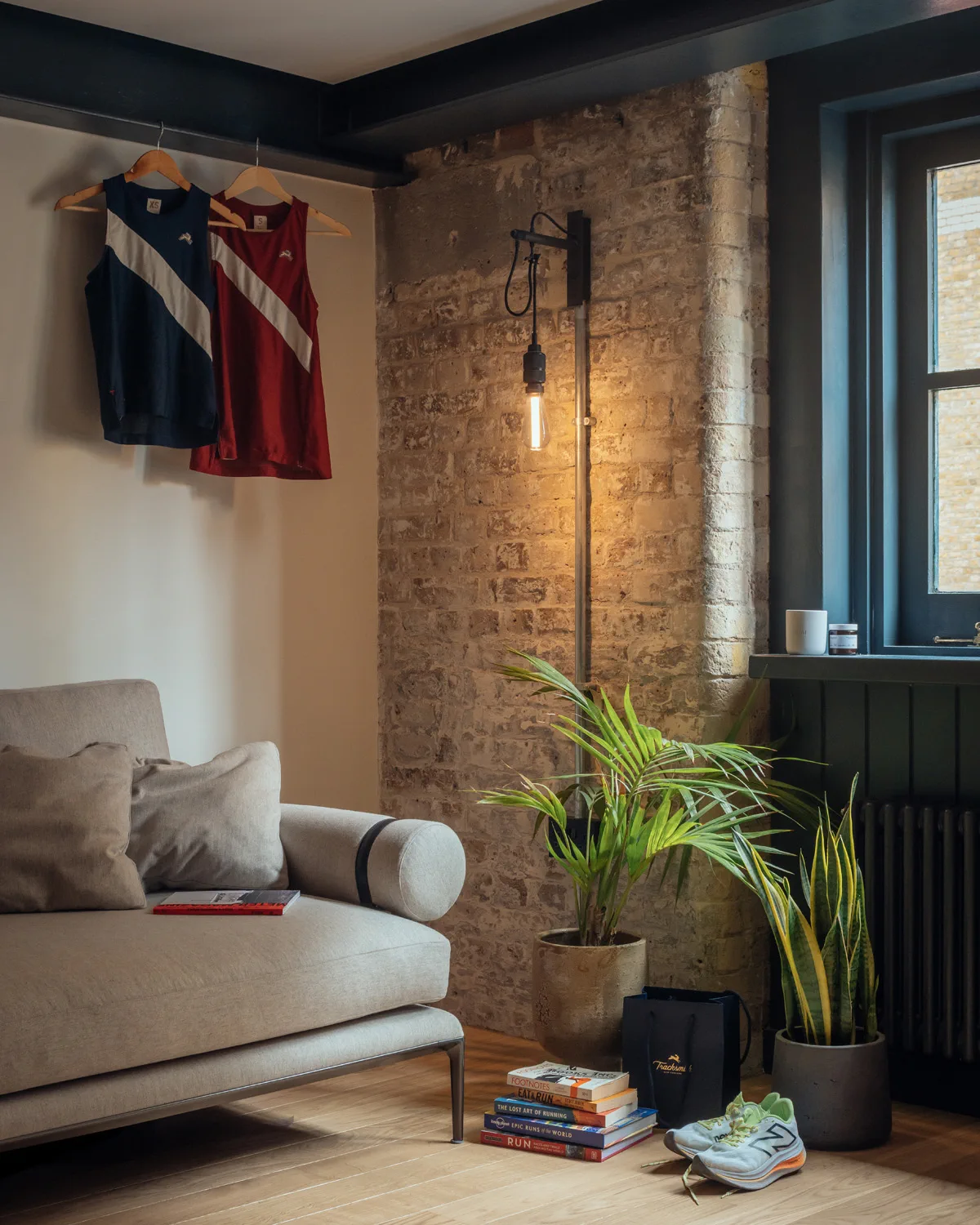 Sofa, teglvegg, plante og sort radiator