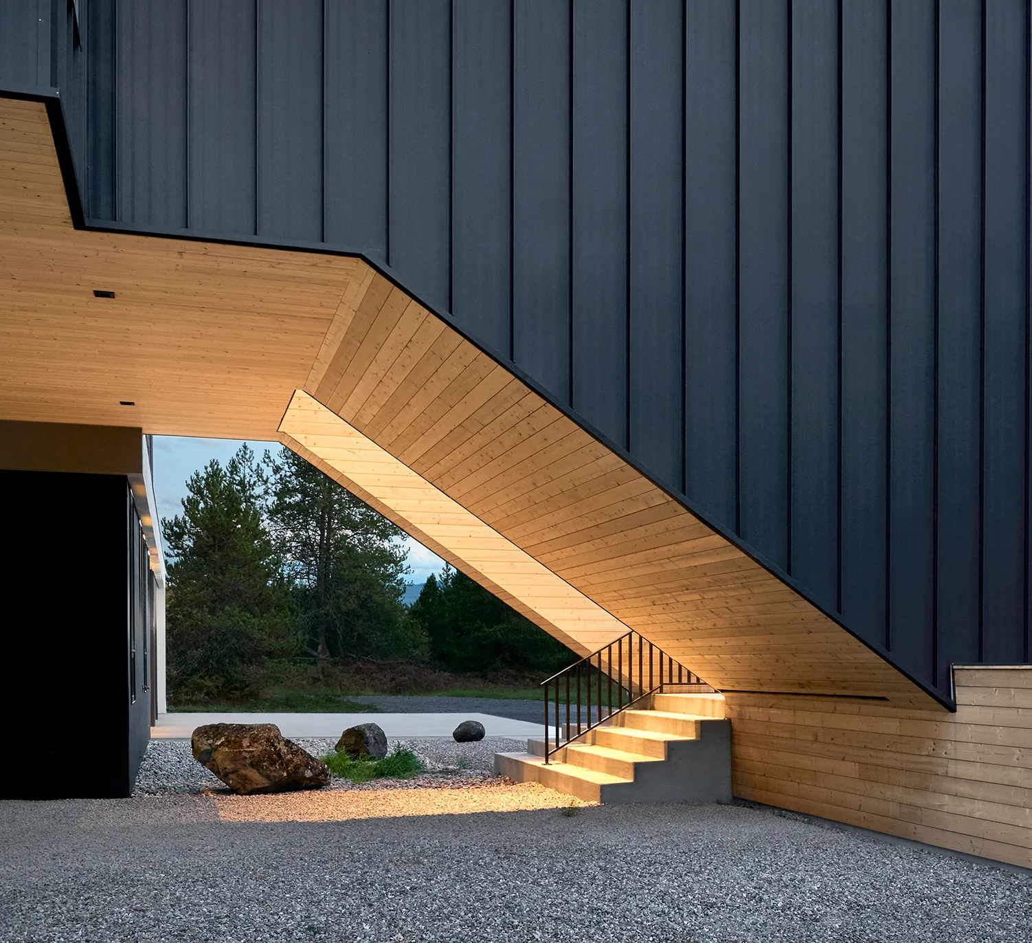 Detalj av hus over terreng med underside, trapp, treverk og mørk kledning