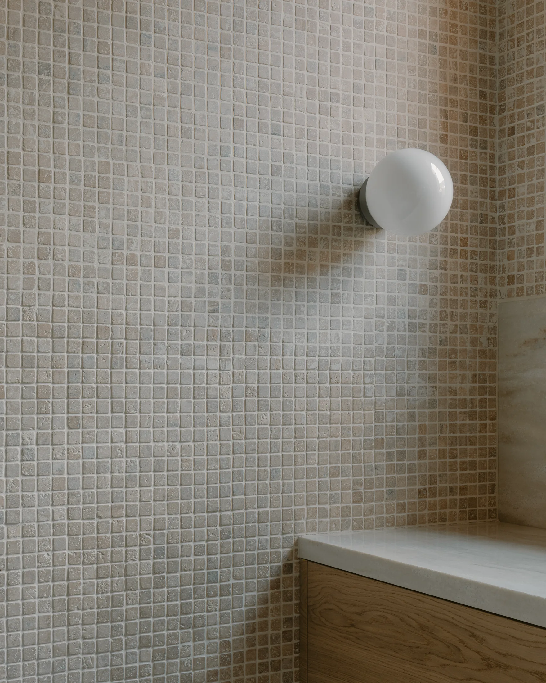 Mosaikkflis, rund lampe og servantdetalj