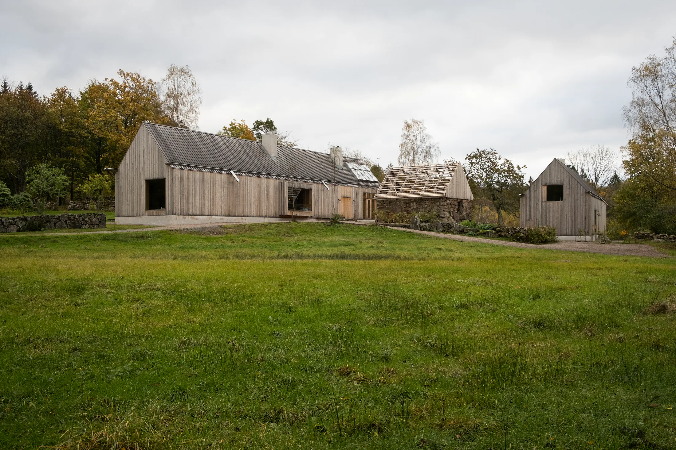 Trekledd bolig og uthus ved grønn plen